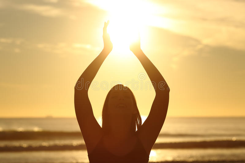 woman-holding-sun-sunset-front-view-back-light-faithful-silhouette-beach-sunrise-warm-backgrou...jpg