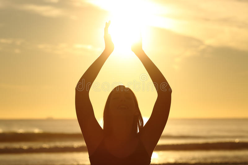 woman-holding-sun-sunset-front-view-back-light-faithful-silhouette-beach-sunrise-warm-background.jpg