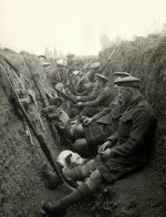 A group of men sitting next to each other in a trench. WWI, 1914.jpeg