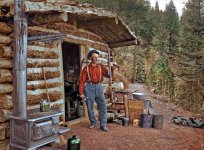 A prospector standing outside a log cabin in Pikes Peak, Colorado in 1900. 124 years ago.jpeg